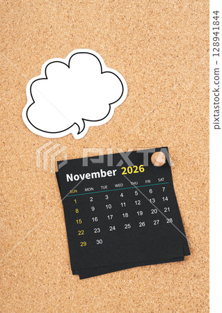 November 2026 Black calendar page and blank speech bubble with thumbtack on wooden board. November 2026 Black calendar page and blank speech bubble with thumbtack on wooden board. 128941844
