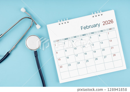 February 2026 desk calendar and stethoscope on blue color, Medical appointment concept. February 2026 desk calendar and stethoscope on blue color, Medical appointment concept. 128941858