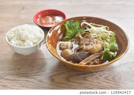 boiled braised beef meat and tendon couple organ in herb brown soup on bowl dipping spicy chili sauce eat couple with plain rice 128942417