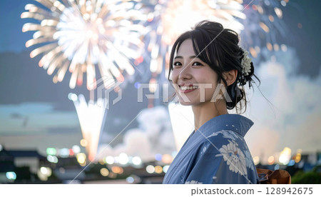 Fireworks in the summer night sky and a smiling woman in a yukata 128942675