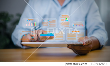 Data analytics concept with businessman using tablet to analyze digital report and charts. Business intelligence and technology dashboard. Data analytics concept with businessman using tablet to analyze digital report and charts. Business intelligence and technology dashboard. 128942835