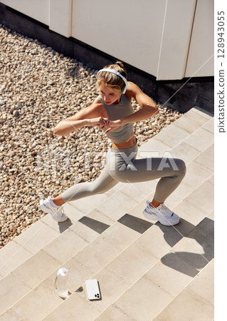 Active female exercising outdoors in a modern fitness and health lifestyle Active female exercising outdoors in a modern fitness and health lifestyle 128943055