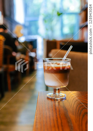 Iced Latte Moment in a Cozy Book Cafe Iced Latte Moment in a Cozy Book Cafe 128943084