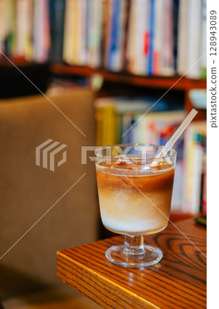 Iced Latte Moment in a Cozy Book Cafe Iced Latte Moment in a Cozy Book Cafe 128943089