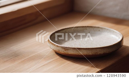 Japanese-style ceramic plate and natural light shining on a wooden table_2 128943590