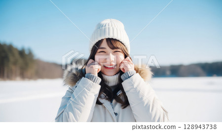 A woman smiling in a winter snow scene A woman smiling in a winter snow scene 128943738