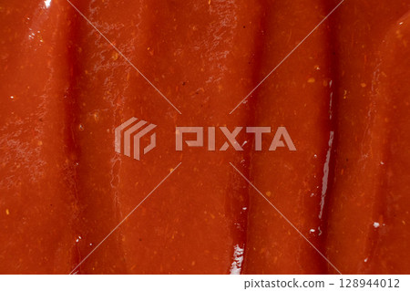 Red Ketchup Surface Close-Up. Ingredient Background for Design. Red Ketchup Surface Close-Up. Ingredient Background for Design. 128944012