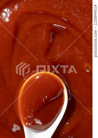 Traditional Ketchup in Spoon Macro. Organic Culinary Element. 128944014