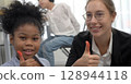 African kid with caucasian teacher diversity fun interactive learning environment school 128944118