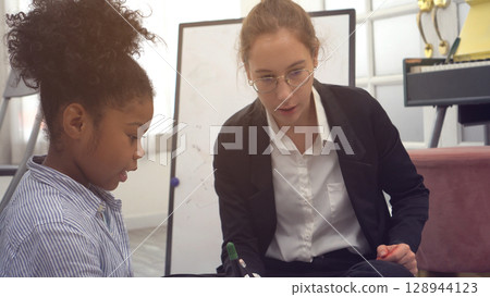African kid with caucasian teacher diversity fun interactive learning environment school 128944123