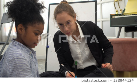African kid with caucasian teacher diversity fun interactive learning environment school 128944124