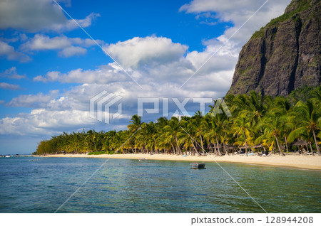 Tropical beach with boats, palm trees, and Le Morne Brabant mountain, Mauritius Tropical beach with boats, palm trees, and Le Morne Brabant mountain, Mauritius 128944208
