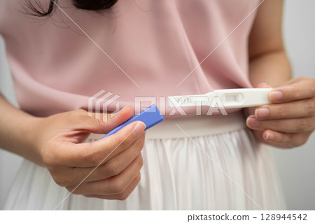 Asian holding pregnancy test for female of ovulation day, fetus, maternity, childbirth, birth control. Asian holding pregnancy test for female of ovulation day, fetus, maternity, childbirth, birth control. 128944542