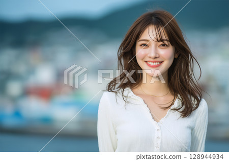 Outdoor portrait of a young woman with a charming natural smile Outdoor portrait of a young woman with a charming natural smile 128944934