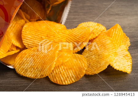 Potato chips , delicious BBQ seasoning spicy for crips, thin slice deep fried snack fast food. 128945413