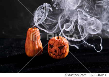 Halloween-style candles on a dark background. Festive decor. 128946041
