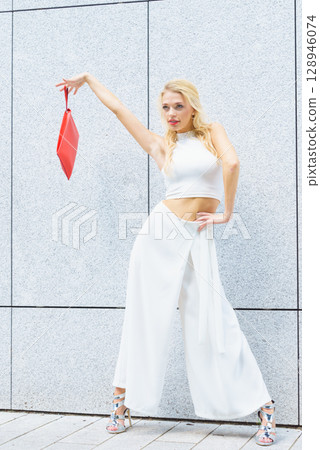 Fashion woman white outfit with red handbag 128946074