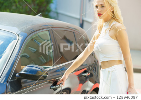 Fashionable woman opening car 128946087