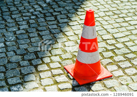 White and oranger traffic cone on street White and oranger traffic cone on street 128946091