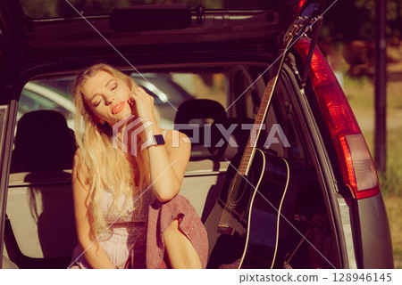 Hippie woman with guitar in van car 128946145