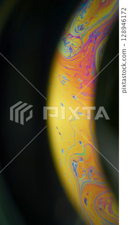 Gasoline fluid. Mystical paint. Colorful arch emulsion orange yellow oil dye mixing texture. Glowing blur background black night space. 128946172