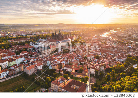 Prague Castle stands majestically against the vibrant sky at sunrise. The soft light illuminates the city, showcasing its beautiful architecture and historic charm as the day begins. Prague Castle stands majestically against the vibrant sky at sunrise. The soft light illuminates the city, showcasing its beautiful architecture and historic charm as the day begins. 128946308