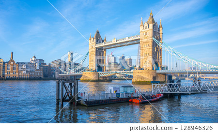 Morning at Tower Bridge reveals a stunning view with clear skies and soft light reflecting on the Thames River. The iconic structure stands majestically against the London skyline. Morning at Tower Bridge reveals a stunning view with clear skies and soft light reflecting on the Thames River. The iconic structure stands majestically against the London skyline. 128946326