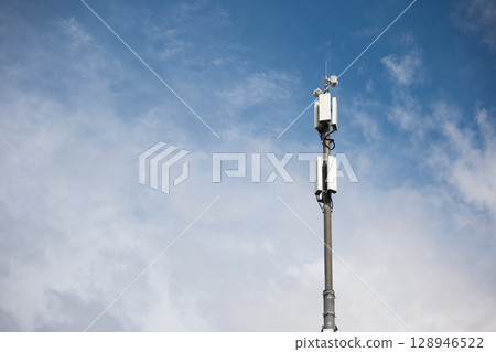 Cellular antenna tower against a blue sky with clouds showcasing modern communication technology 128946522
