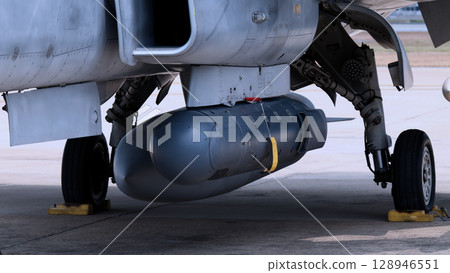 Close up of modern aircraft military fighter jet. Close up Jet parts such as landing gear engine nacelles weapon pods and cockpit with visible pilots showing defense technology and aircraft design. Close up of modern aircraft military fighter jet. Close up Jet parts such as landing gear engine nacelles weapon pods and cockpit with visible pilots showing defense technology and aircraft design. 128946551