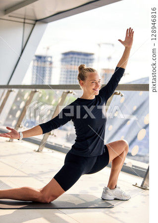 Woman practicing yoga in a sunny modern studio Woman practicing yoga in a sunny modern studio 128946816