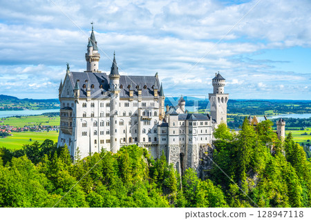 Nestled among lush hills and scenic views, Neuschwanstein Castle stands majestically in Bavaria, Germany. Its fairytale architecture attracts visitors seeking mystery and enchantment. Nestled among lush hills and scenic views, Neuschwanstein Castle stands majestically in Bavaria, Germany. Its fairytale architecture attracts visitors seeking mystery and enchantment. 128947118