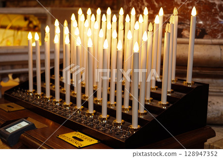 A candle flame lit by money donated to the church 128947352