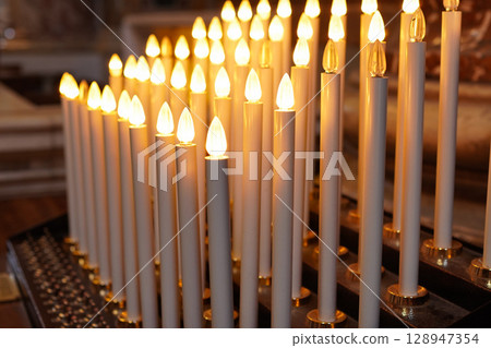 A candle flame lit by money donated to the church 128947354