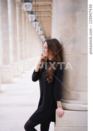 Pensive woman leaning on column in Paris 128947436
