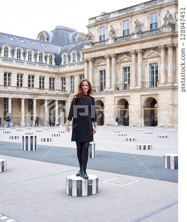 Stylish woman posing on art column in Paris 128947451