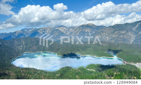 Aerial view of Eibsee Lake in Germany, surrounded by lush green forests and majestic mountains under Aerial view of Eibsee Lake in Germany, surrounded by lush green forests and majestic mountains under 128949084