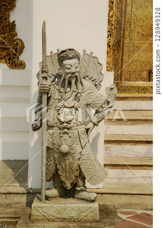 Chinese guardian statue at the gate of Wat Pho Which is one of the largest and oldest temples in Bangkok and is popular with both Thai and foreign tourists. 128949328