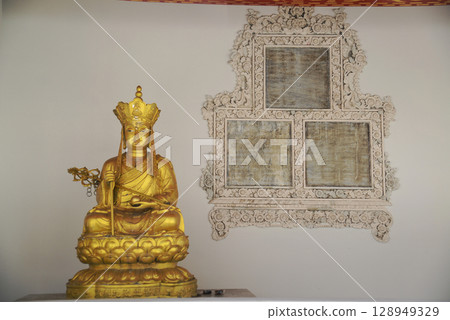 A golden Chinese-style Buddha statue is decorated in the Sala Rai at Wat Pho, one of the largest and oldest temples in Bangkok and a popular destination for both Thai and foreign tourists. 128949329