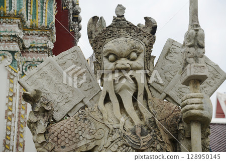 Chinese guardian statue at the gate of Wat Pho Which is one of the largest and oldest temples in Bangkok and is popular with both Thai and foreign tourists. 128950145