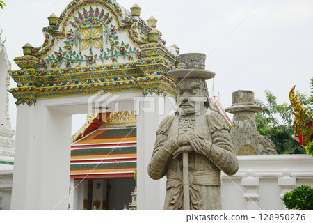 Chinese guardian statue at the gate of Wat Pho Which is one of the largest and oldest temples in Bangkok and is popular with both Thai and foreign tourists. 128950276