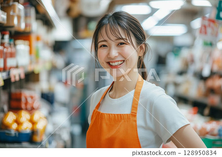 Female retail store clerk | Staff in aprons and friendly smiles 128950834