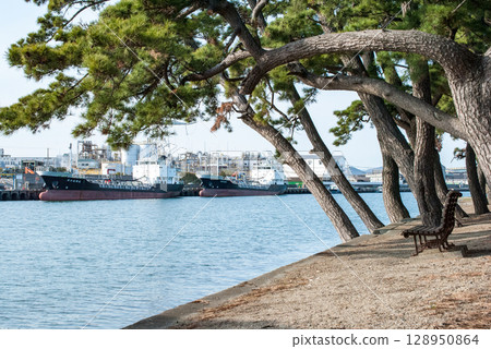 兵庫縣高砂市加古川河口的公園風景,有船、松樹和長椅 兵庫縣高砂市加古川河口的公園風景,有船、松樹和長椅 128950864