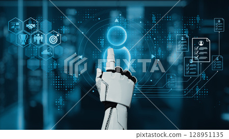 Futuristic Robot Hand Interacting with Digital User Interface in High-Tech Environment Representing Artificial Intelligence and Human Interaction. Auvana 128951135