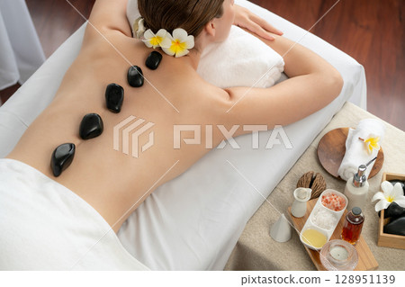 Hot stone massage at spa salon in luxury resort. Quiescent 128951139