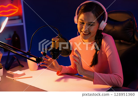 Smiling creative young beautiful Asian influencer talking in channel. Stratagem. 128951360