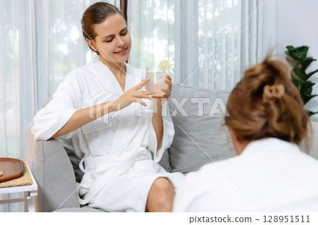 Couple wearing bathrobe relaxing with drinks in luxurious hotel spa. Quiescent Couple wearing bathrobe relaxing with drinks in luxurious hotel spa. Quiescent 128951511
