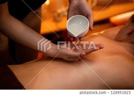Masseuse prepare oil massage procedure for customer at spa. Quiescent 128951625
