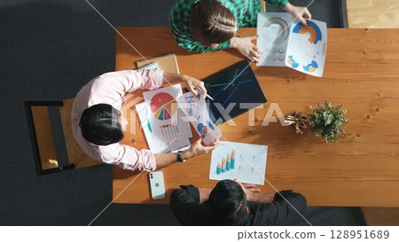 Top view of manager holding document to present graph to investor. Convocation. Top view of manager holding document to present graph to investor. Convocation. 128951689