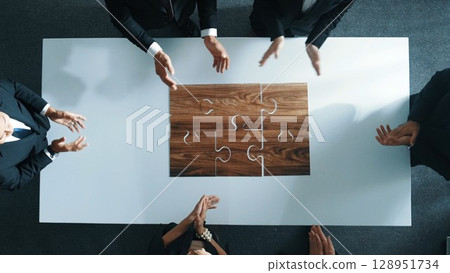Top view of businesspeople putting jigsaw together at meeting room. Directorate. 128951734