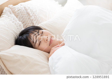 A woman sleeping in bed A woman sleeping in bed 128951891
